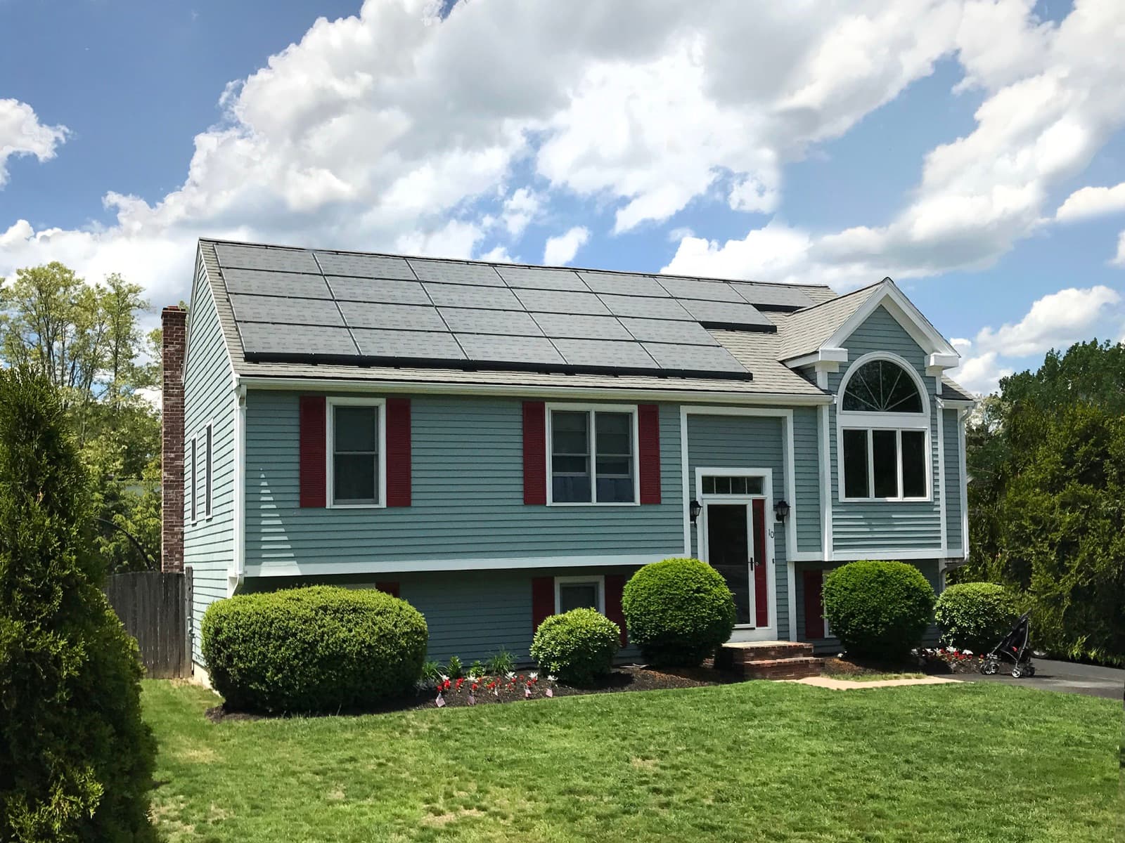US home with a rooftop solar array on a pitched asphalt-shingle roof